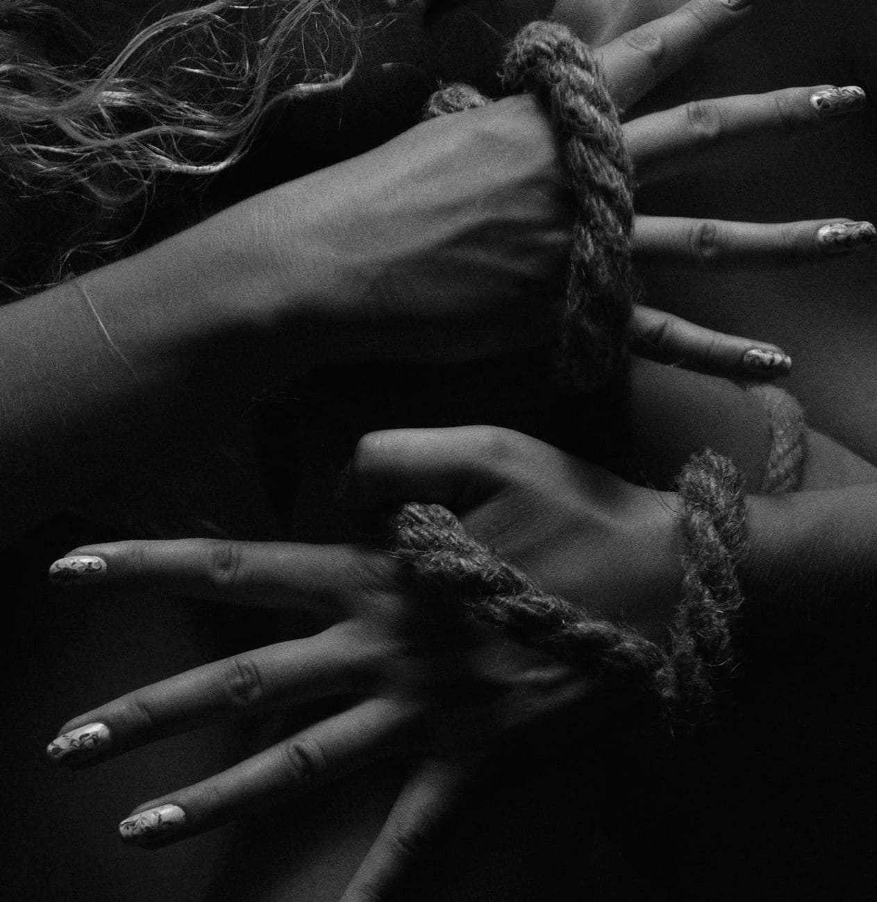 person s hands tied in a rope